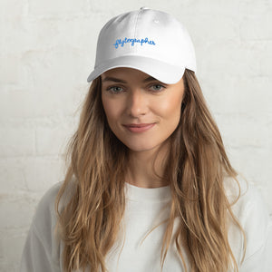 woman is wearing 100% Chino cotton twill baseball cap that hat has a low profile with an adjustable strap and curved visor.