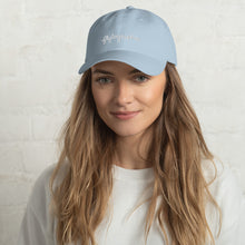 Load image into Gallery viewer, Model is wearing a light blue baseball cap that has a low profile with an adjustable strap and curved visor.
