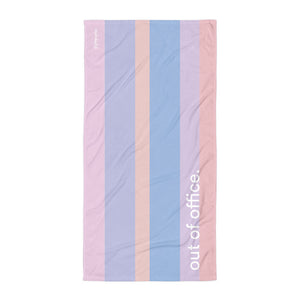 Beach towel in a colourful stripe pattern and words "out of office" written on front
