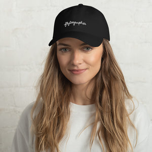Model is wearing a black baseball cap that has a low profile with an adjustable strap and curved visor.